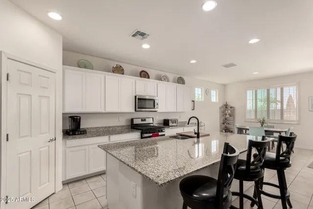 a kitchen with granite countertop a sink stove and cabinets
