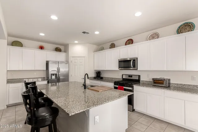 a kitchen with granite countertop a sink a counter top space appliances and cabinets