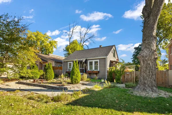 a view of a house with a tree in front of it
