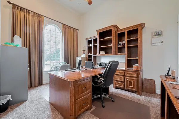 a view of a workspace with furniture and a window