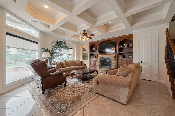 a living room with furniture a fireplace and a large window