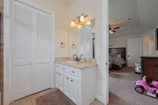 a en suite bathroom with a double vanity sink and a mirror