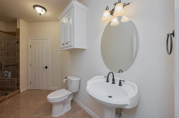 a bathroom with a sink a toilet and a mirror