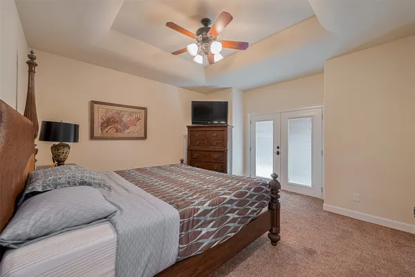 a bedroom with a large bed a chandelier and closet