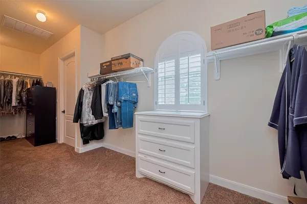 a view of walk in closet with clothes and shoes