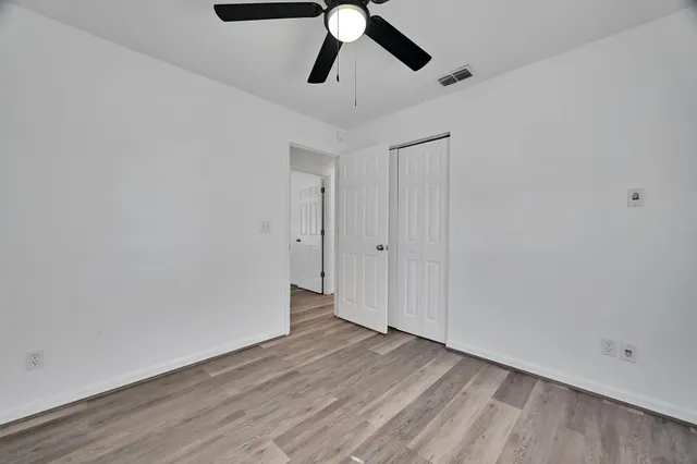 a view of empty room with wooden floor