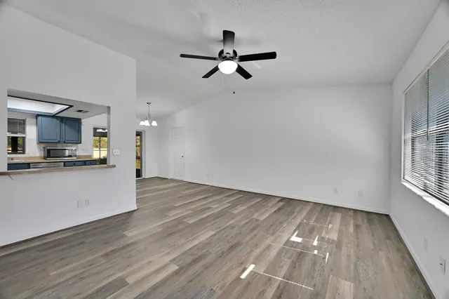 a view of empty room with wooden floor and window