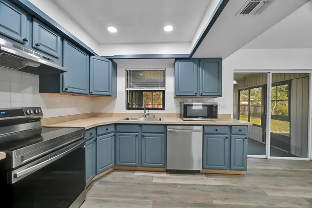 a kitchen with stainless steel appliances granite countertop wooden cabinets a sink and dishwasher