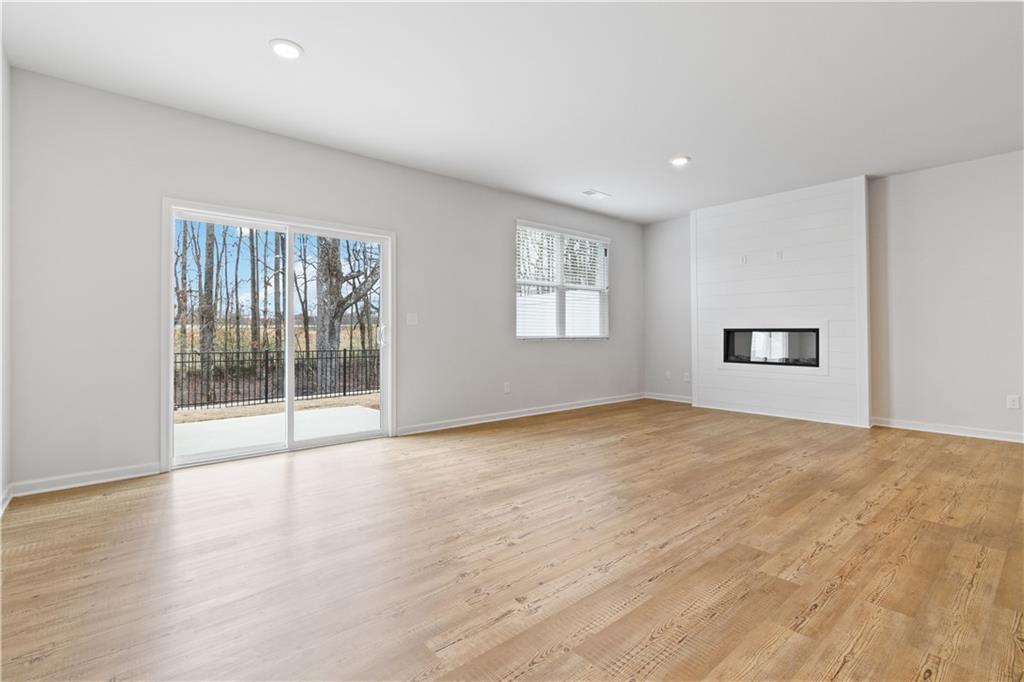 5113 Sidney Sq Drive Flowery Branch, GA 30542 - Photo 11 of 35 a view of an empty room with a window and wooden floor