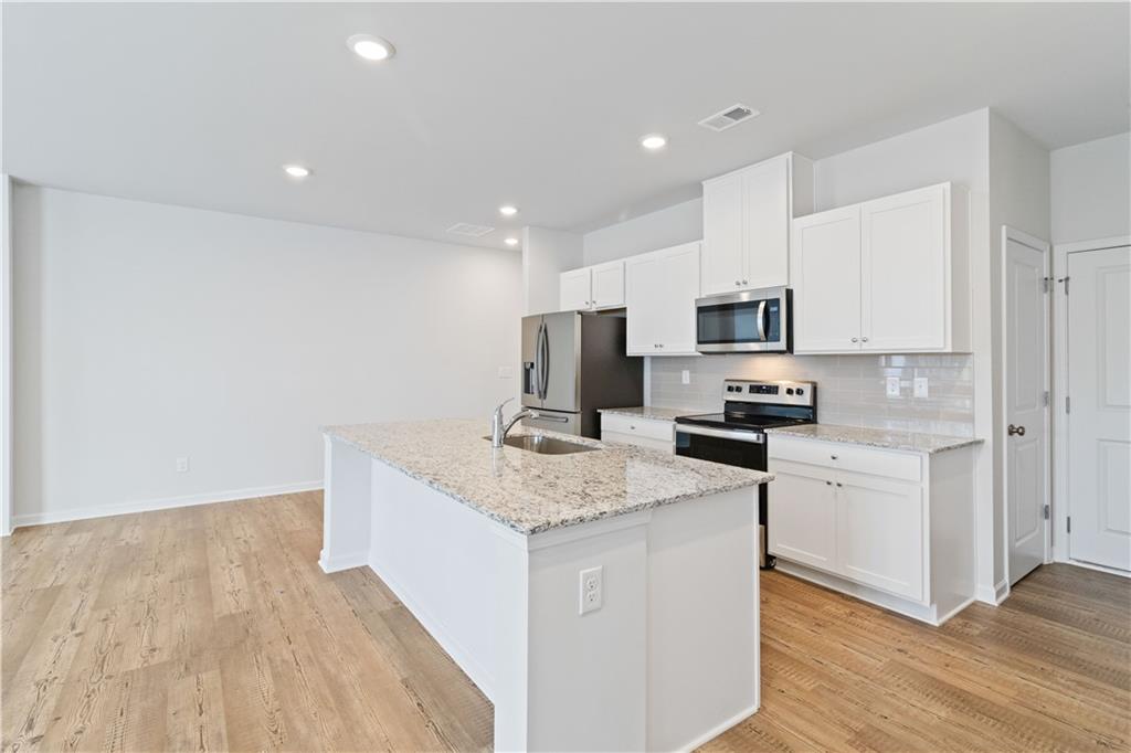 5113 Sidney Sq Drive Flowery Branch, GA 30542 - Photo 15 of 35 a kitchen with a sink a counter top space stainless steel appliances and cabinets