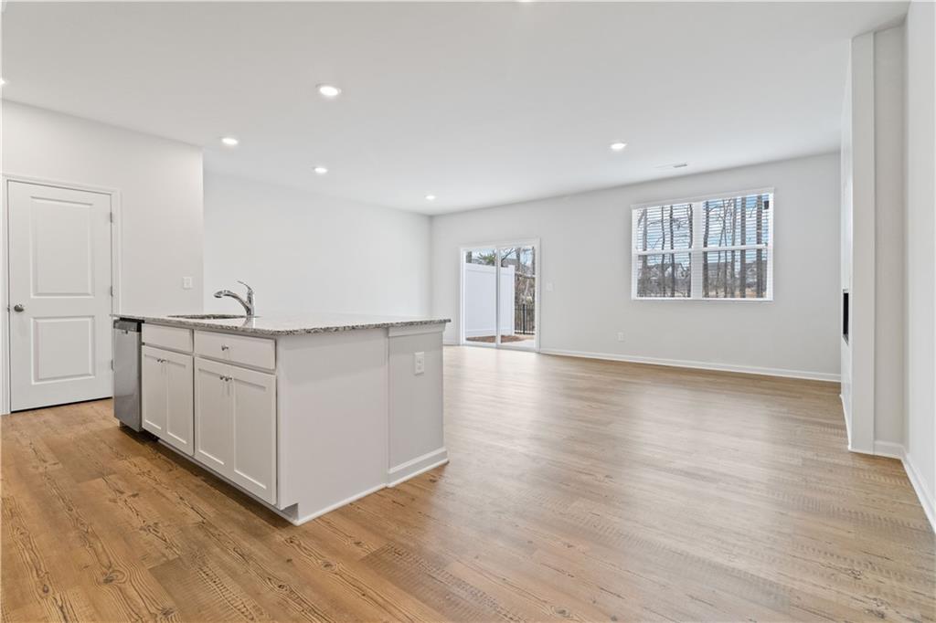 5113 Sidney Sq Drive Flowery Branch, GA 30542 - Photo 6 of 35 a view of a kitchen with wooden floor and windows
