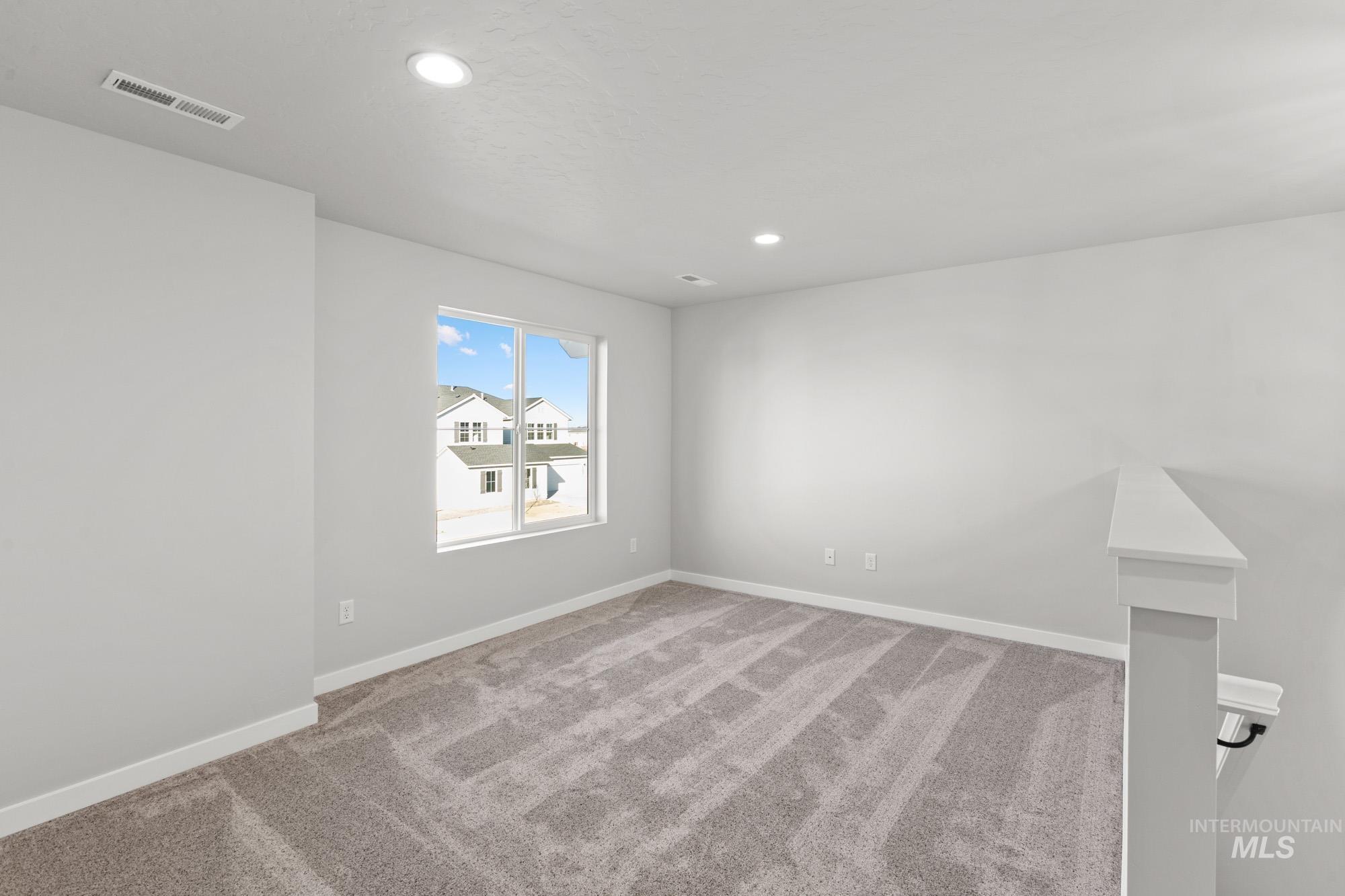 13713 Judson Street Caldwell, ID 83607 - Photo 12 of 24 Empty room featuring light colored carpet and recessed lighting