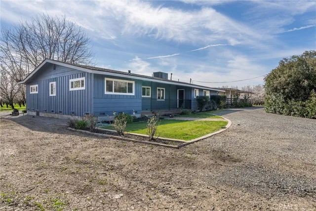 a view of a house with a yard and large tree
