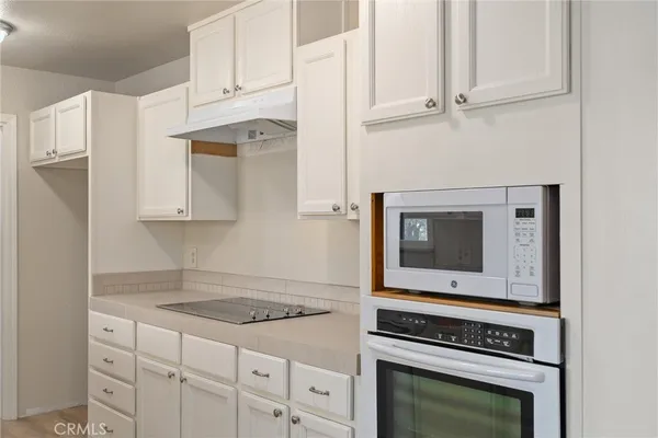 a kitchen with white cabinets and appliances