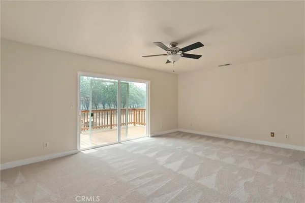an empty room with a ceiling fan and window