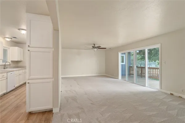 a view of an empty room with cabinet and a window