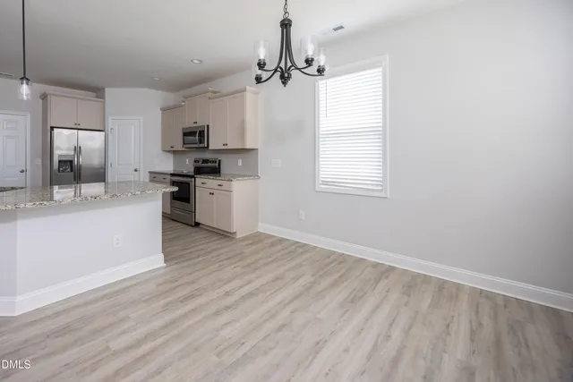 a kitchen with wooden floors and white cabinets
