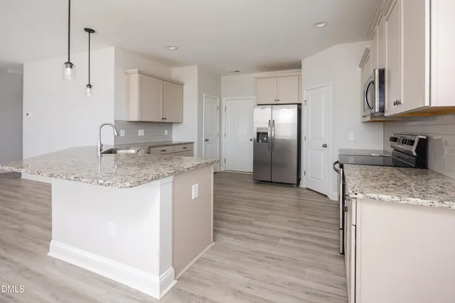 a view of a kitchen with a sink dishwasher cabinets and wooden floor