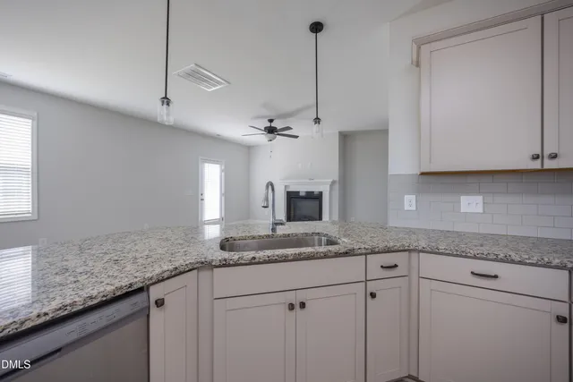 a kitchen with stainless steel appliances granite countertop a sink a stove and a refrigerator