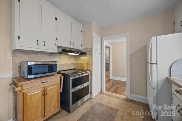 a kitchen with white cabinets and stainless steel appliances