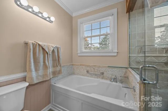 a bathroom with a tub a sink and glass door