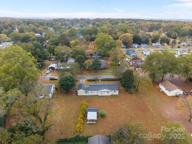 an aerial view of residential houses with outdoor space and trees