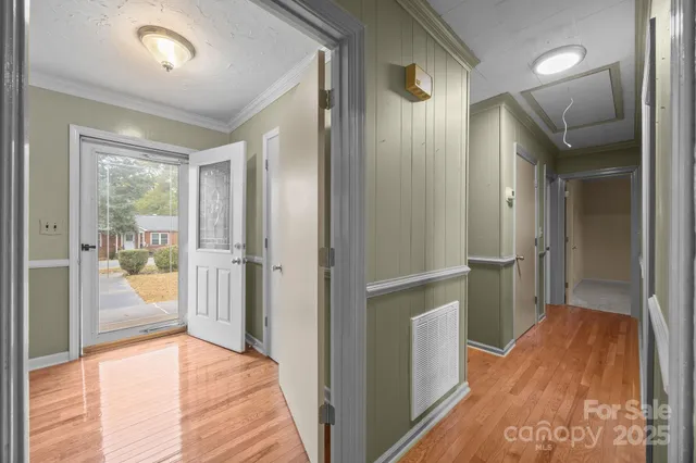 a view of a hallway view with wooden floor and a living room