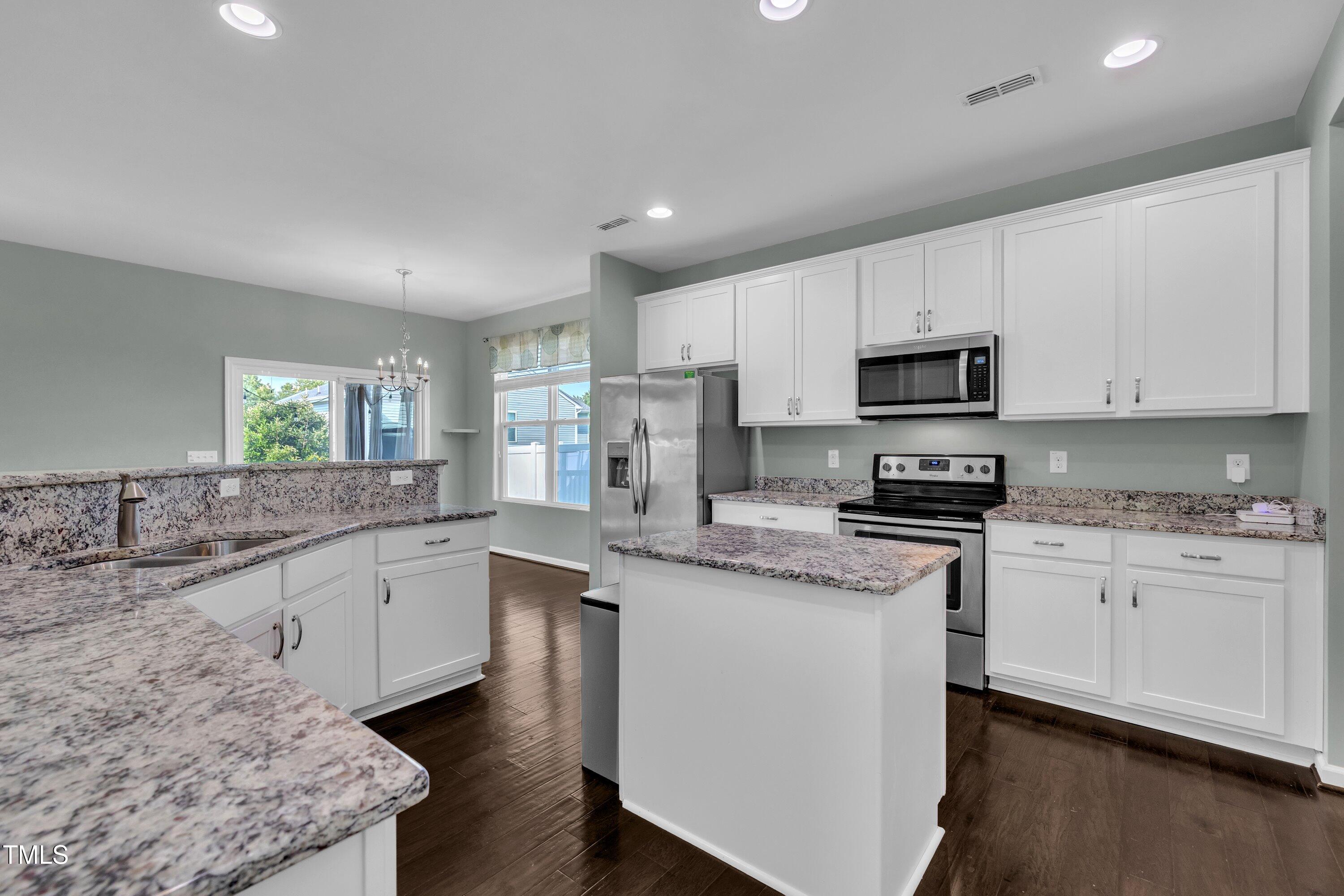 3519 Winding Walk Court Raleigh, NC 27616 - Photo 4 of 43 a kitchen with stainless steel appliances granite countertop a sink stove microwave and refrigerator