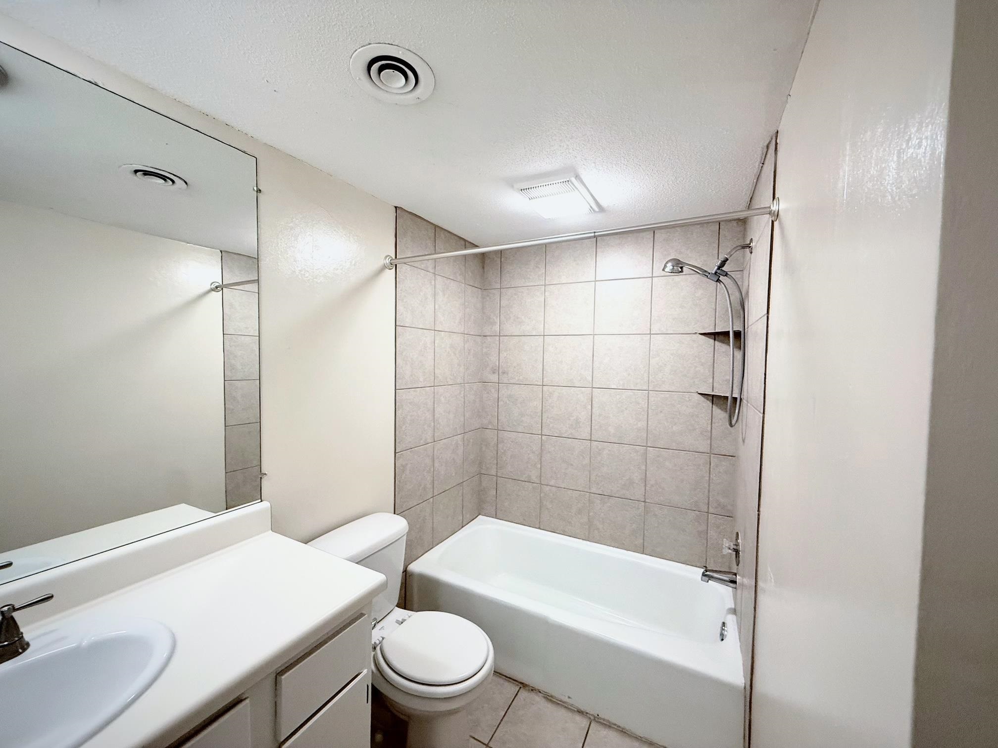 6571 Poplar Avenue, Unit 2 Germantown, TN 38138 - Photo 16 of 18 a bathroom with a bathtub shower sink mirror vanity and toilet