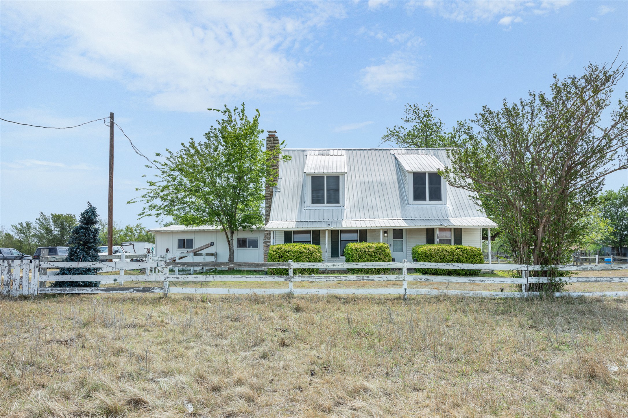 763 Upper Elgin River Road Elgin, TX 78621 - Photo 1 of 40 View of front facade with a fenced front yard, a metal roof, and a chimney