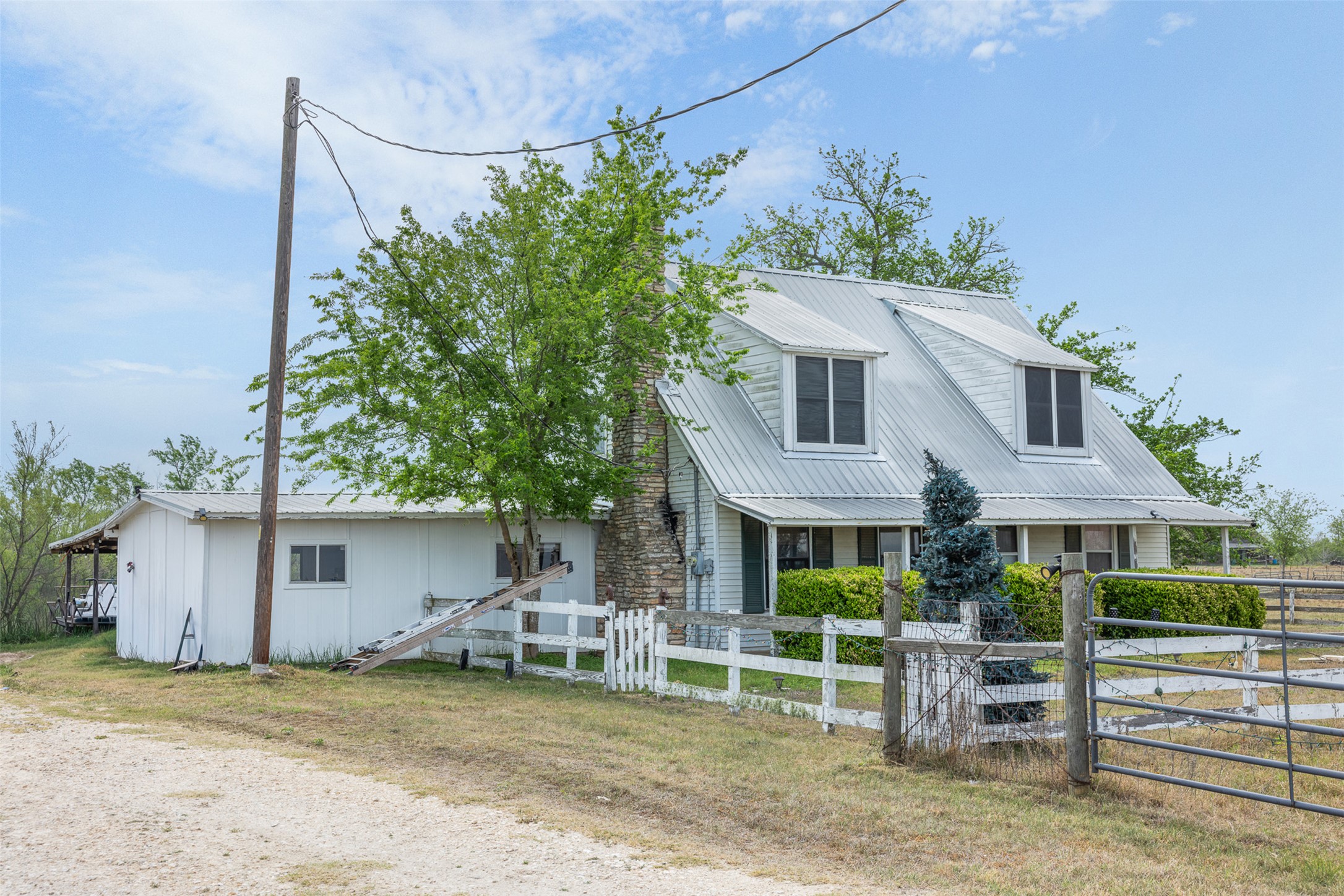 763 Upper Elgin River Road Elgin, TX 78621 - Photo 3 of 40 View of front of property featuring a fenced front yard, a metal roof, and a gate