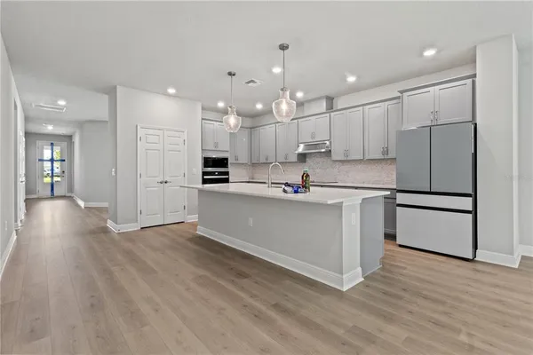 a kitchen with kitchen island white cabinets and stainless steel appliances