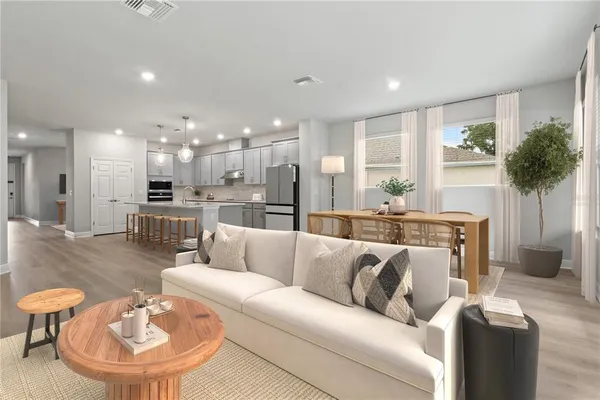 a living room with furniture and a dining table with kitchen view