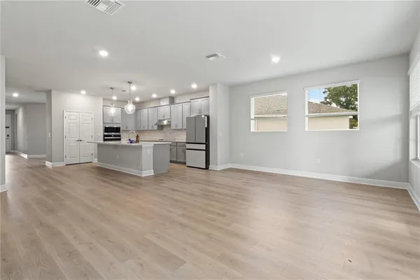 a view of kitchen with kitchen island refrigerator wooden floor and a fireplace