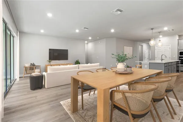 a dining room with furniture a chandelier and kitchen view