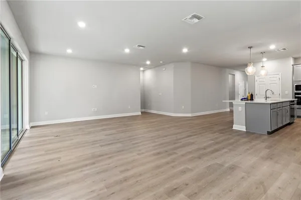 a view of a big room with wooden floor and windows