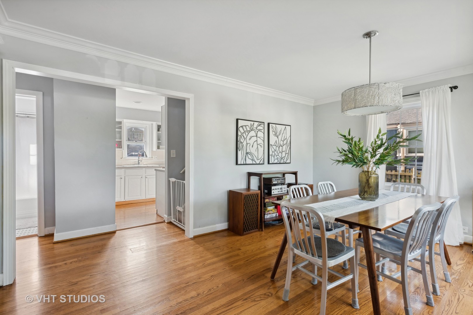 910 Sunset Road Wheaton, IL 60189 - Photo 3 of 29 a dining room with furniture potted plants and wooden floor
