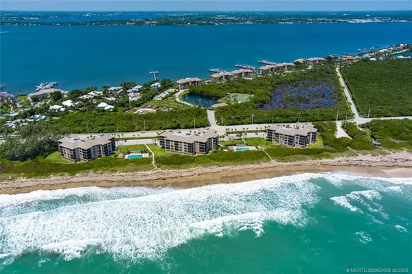 an aerial view of a houses with ocean view