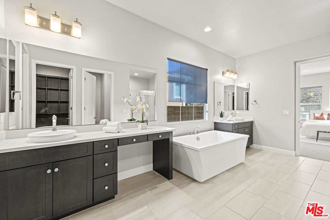 24220 Sterling Ranch Road West Hills, CA 91304 - Photo 21 of 39 a spacious bathroom with a double vanity sink mirror and bathtub