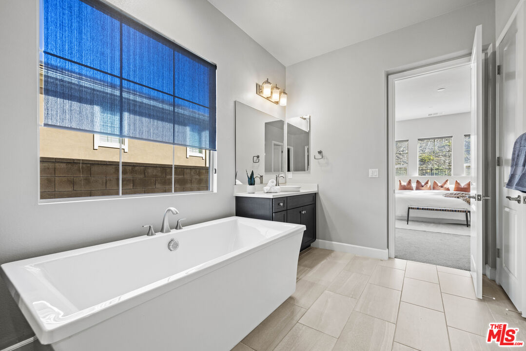 24220 Sterling Ranch Road West Hills, CA 91304 - Photo 23 of 39 a bathroom with a tub sink and mirror