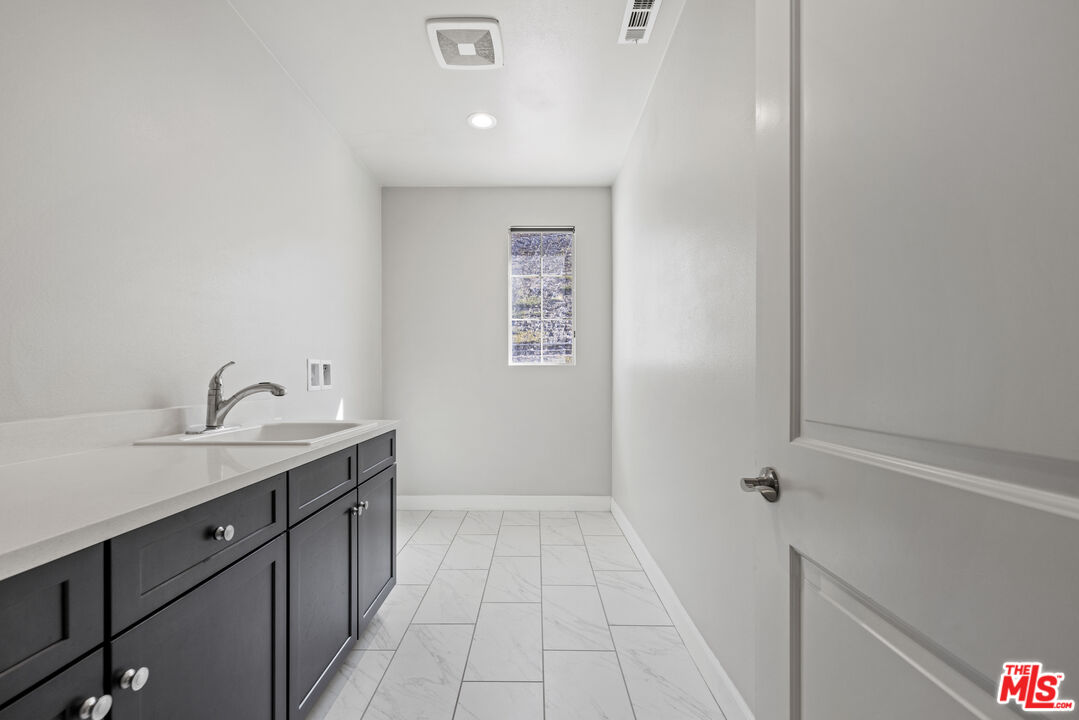 24220 Sterling Ranch Road West Hills, CA 91304 - Photo 27 of 39 a hallway with a sink and a mirror
