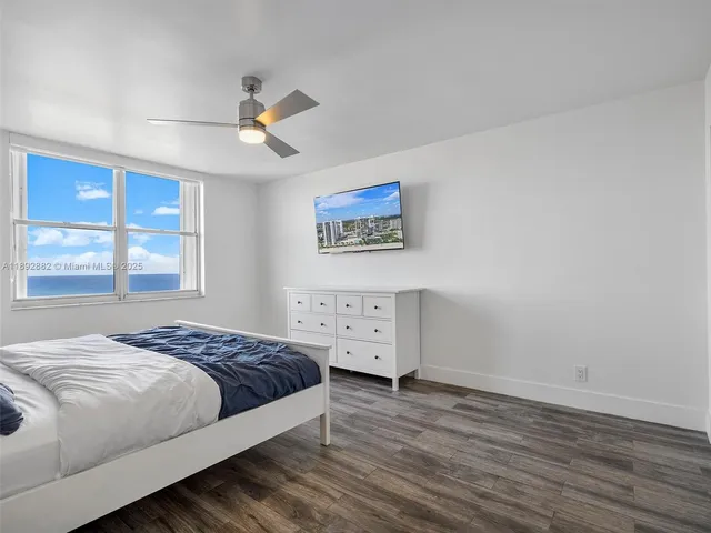 a bedroom with a bed a window and a chandelier