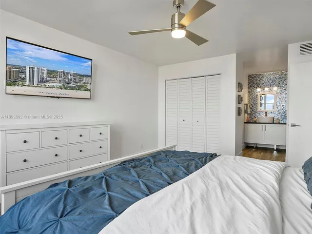a bathroom with a granite countertop sink a toilet a mirror and shower