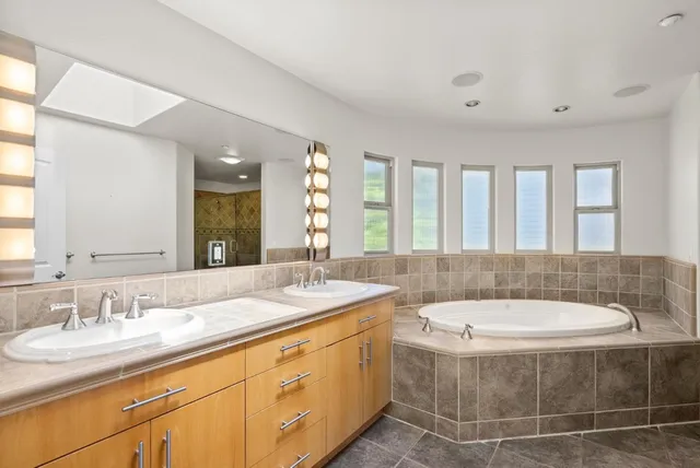 a bathroom with a granite countertop sink and a large mirror