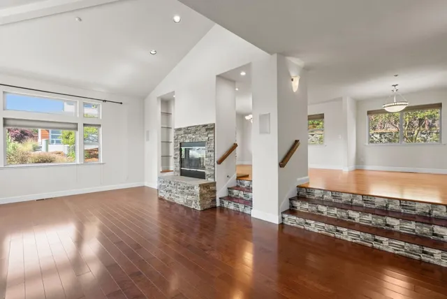 a living room with wooden floor and a book shelf