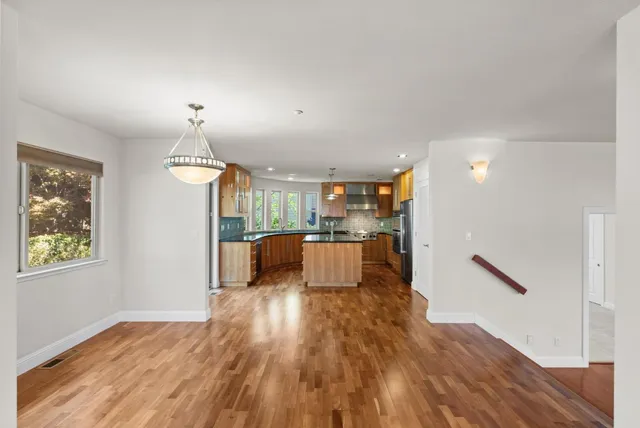 a view of a living room and kitchen with wooden floor