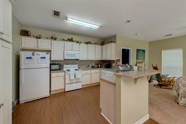 a kitchen with white cabinets and white appliances