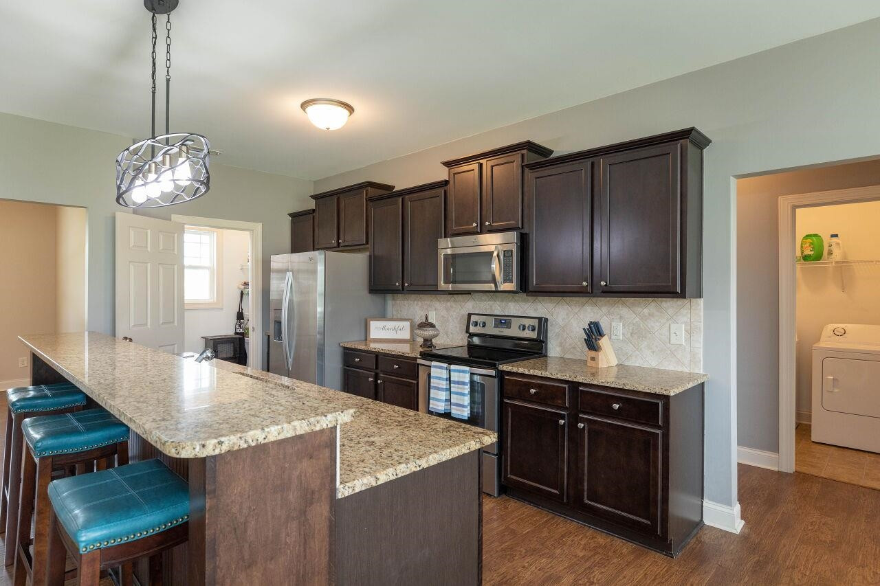 100 Celestial Drive Garner, NC 27529 - Photo 11 of 31 a kitchen with stainless steel appliances granite countertop a sink stove and refrigerator