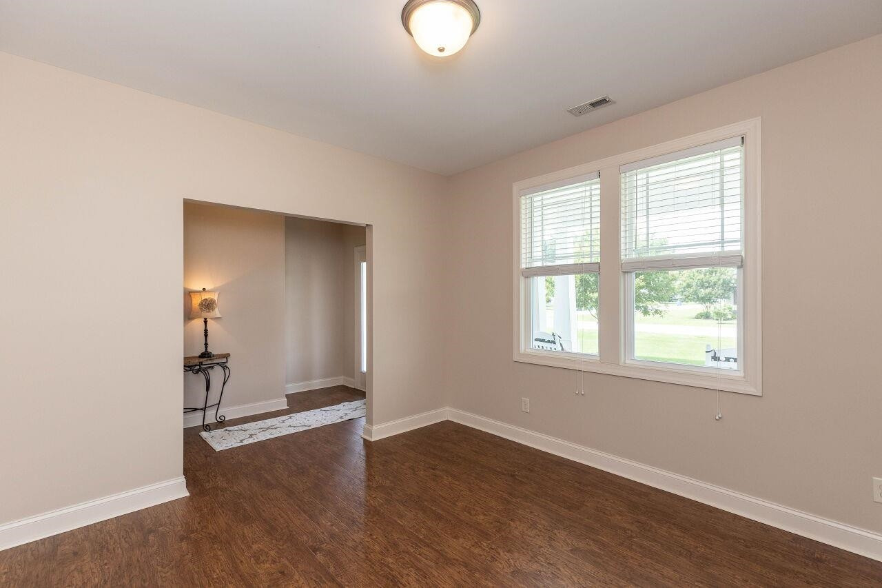 100 Celestial Drive Garner, NC 27529 - Photo 6 of 31 an empty room with wooden floor and windows