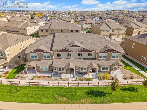 an aerial view of multiple houses with a big yard